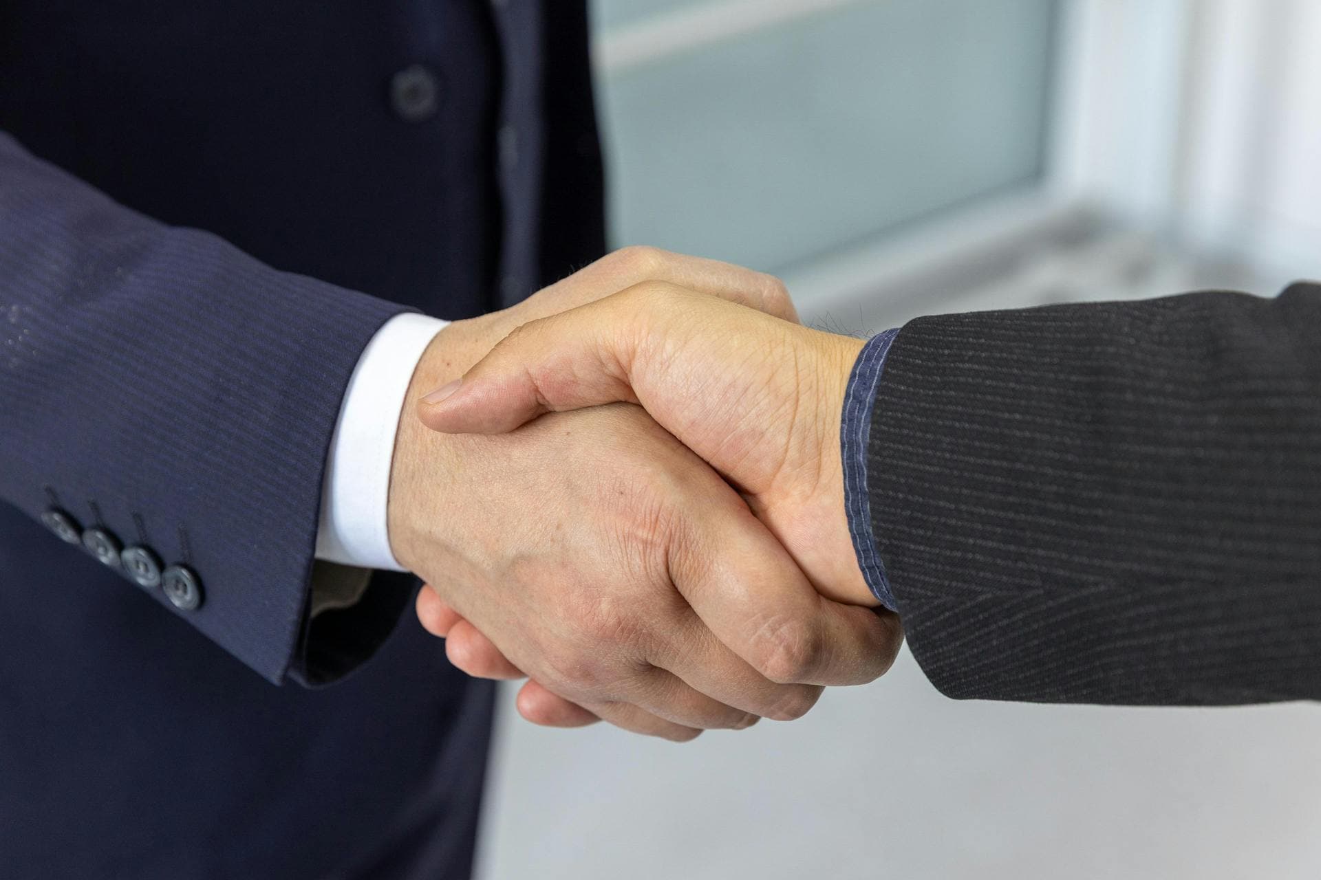 Professioneller Handschlag als Symbol für die Partnerschaft von Stratus und Penguin Solutions